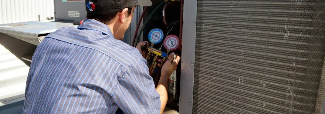 HVAC technician servicing a condenser unit in Lincoln Village