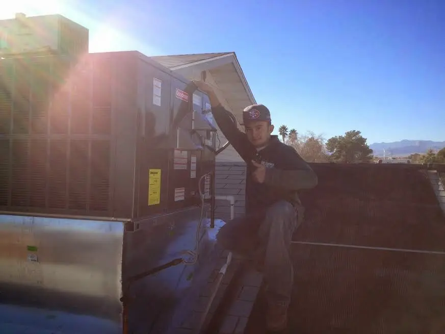 HVAC technician performing Heat Pump Repair on a rooftop unit in Lincoln Village